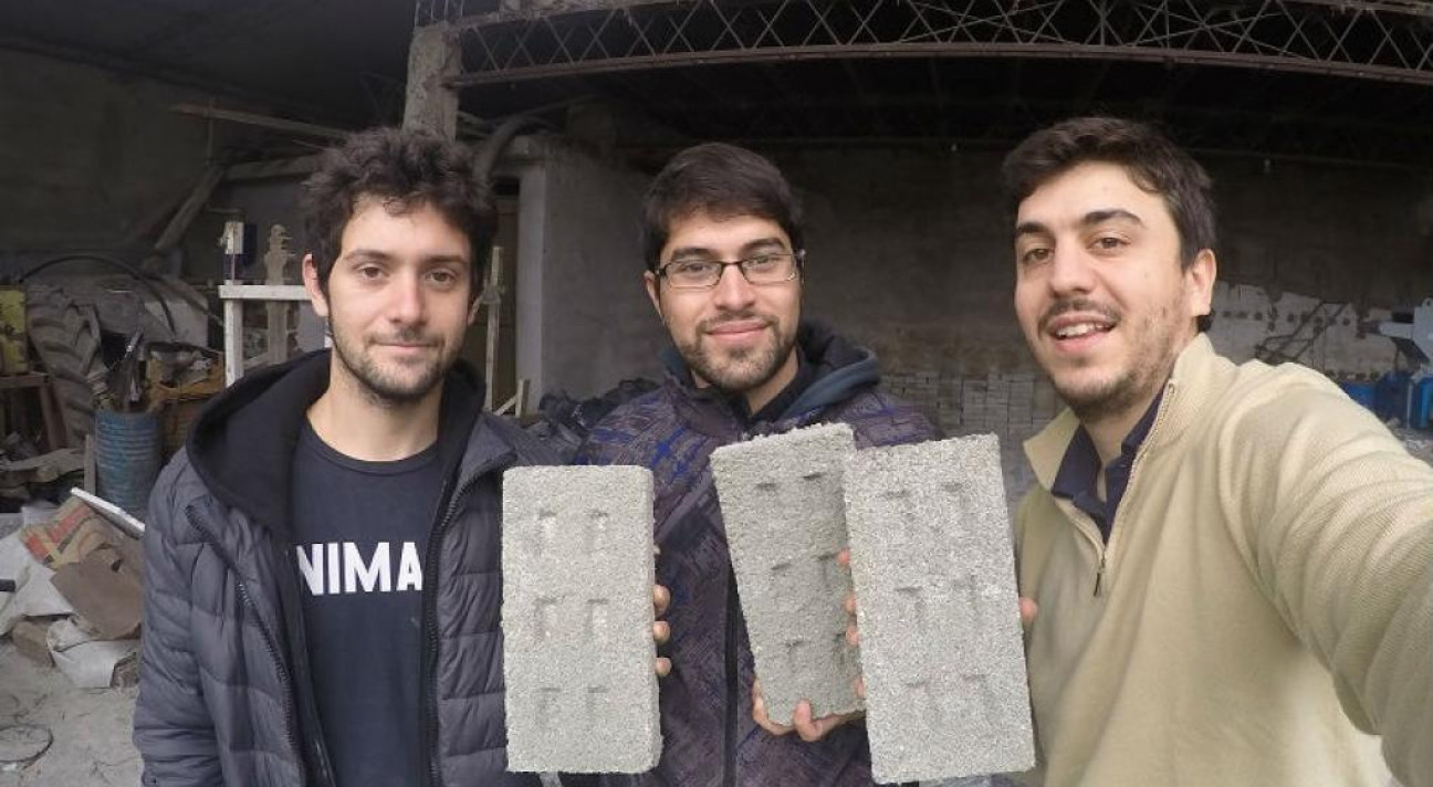 imagen Tres jóvenes fabrican ladrillos con botellas plásticas para usar en la construcción