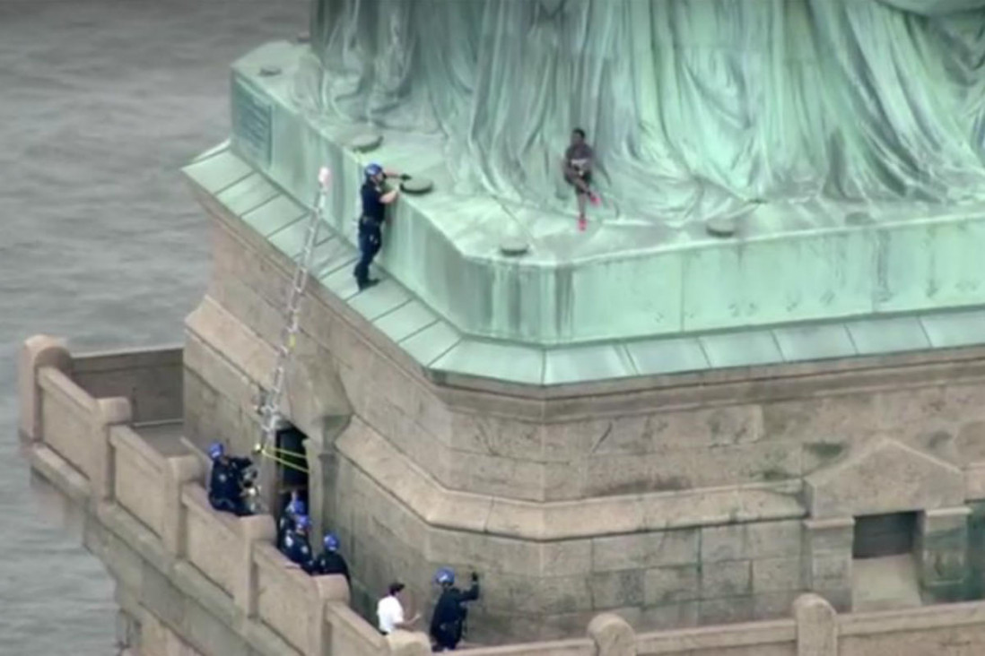 imagen Protesta por política migratoria: mujer intenta escalar la Estatua de la Libertad